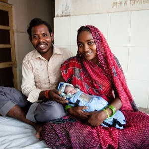 Parents with their newborn in an embrace warmer.