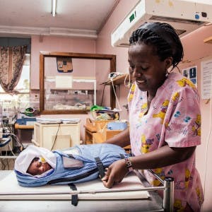Nurse with a newborn in an embrace warmer in Africa
